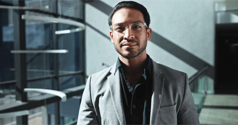 Portrait of a confident business professional in an office building with high-contrast shadows and lighting.