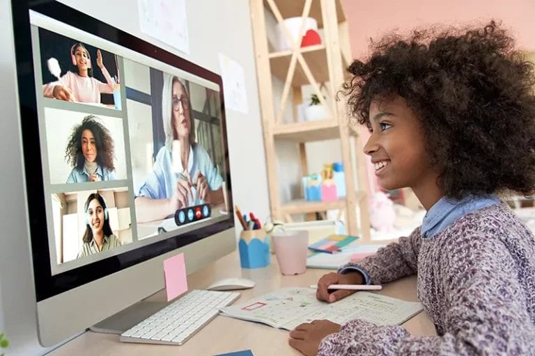 Young student at home computer engages with an online tutor and class.