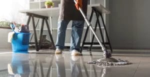 Cropped photo of a cleaner mopping a shiny office space floor.
