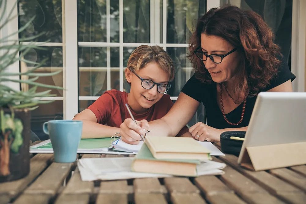 Tutor working with young student at home