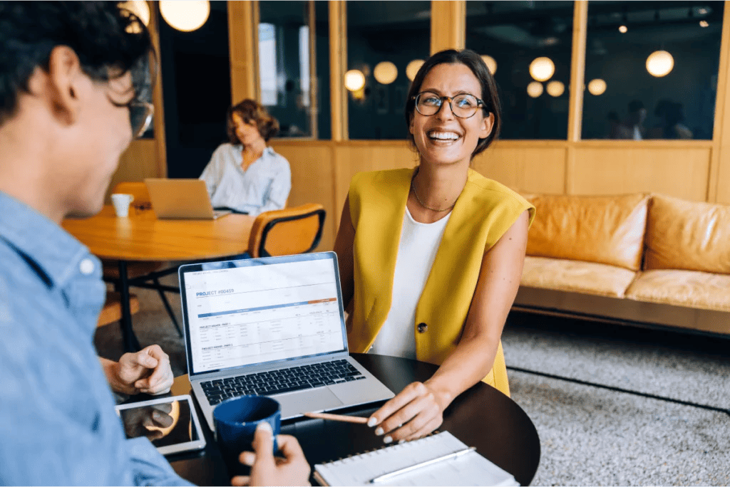 Consultant smiles in a casual client meeting in a warm, modern setting