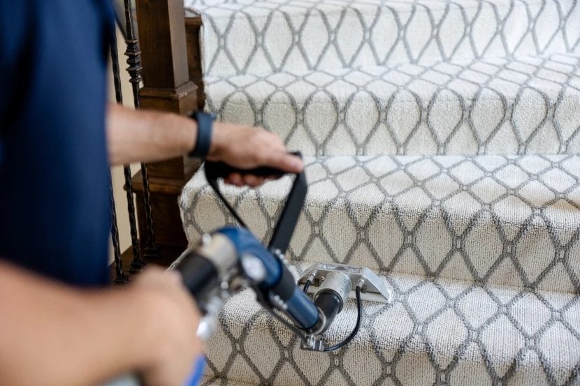 a person cleaning carpet on a staircase