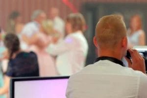 A wedding DJ MCing ta wedding with couples on the dance floor.