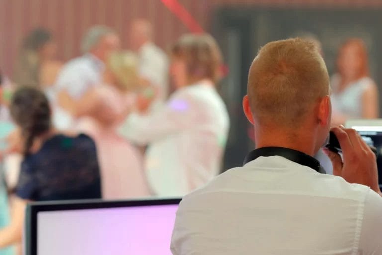 A wedding DJ MCing ta wedding with couples on the dance floor.