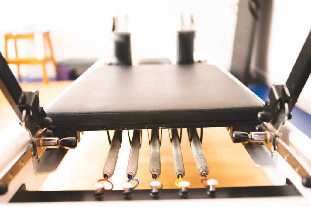 A close-up of a Pilates Reformer machine's springs.