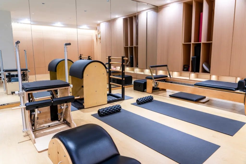 A fully-equipped Pilates studio with mats and machines.