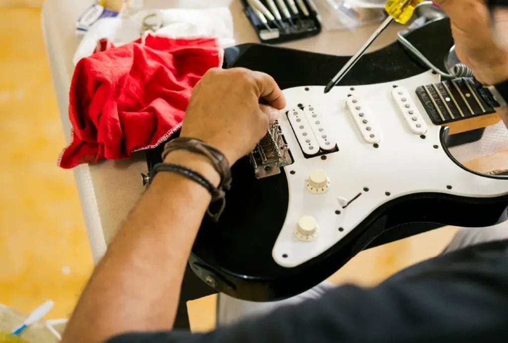 A luthier repairs an electric guitar in their workshop