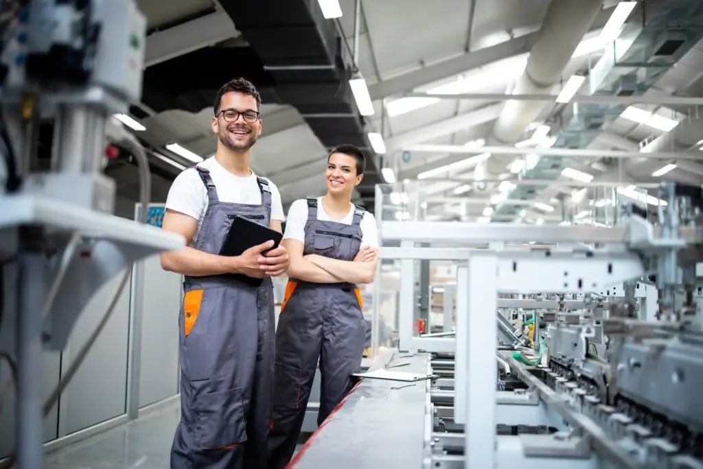 Two production line employees standing in a manufacturing plant.