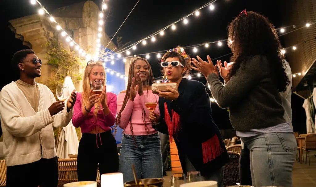 A group of friends is celebrating a birthday together at a private venue.