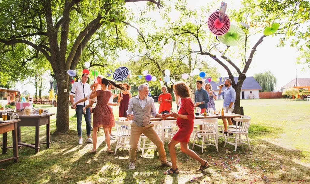 Family members dance around at a small outdoor reunion.
