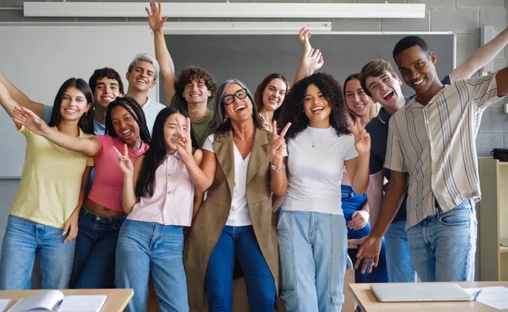 Public school teacher poses for the camera with her class of high school students