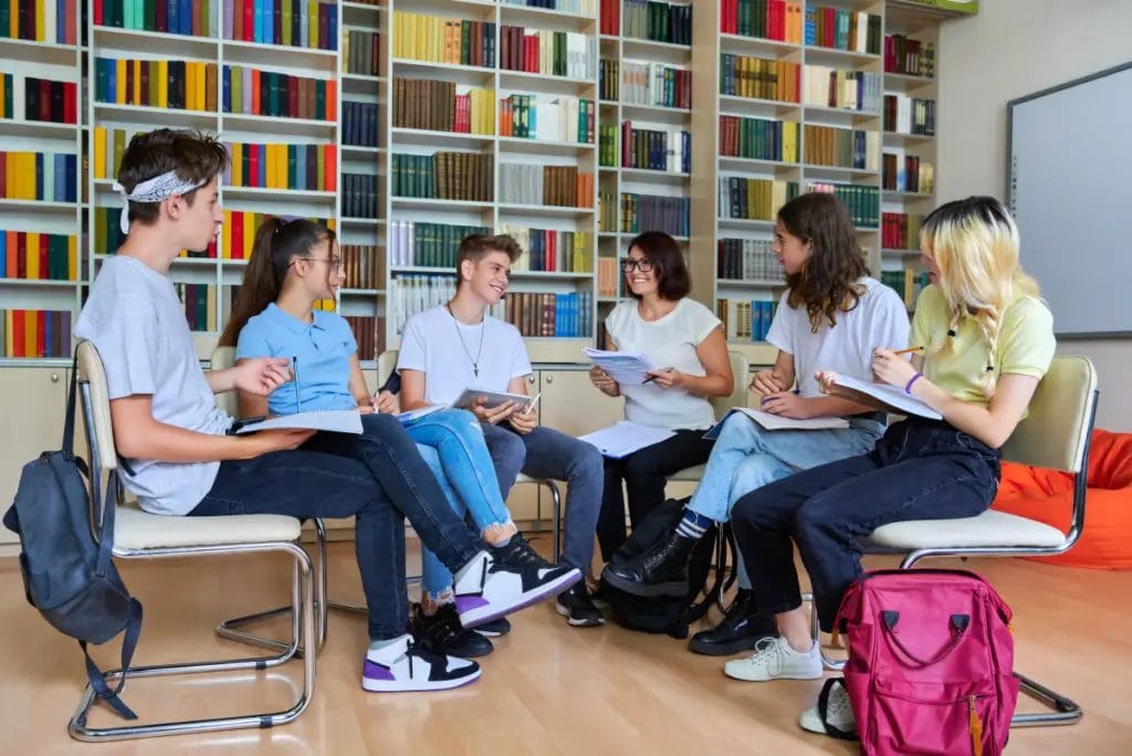 Teacher leads and afterschool study group in a school library.