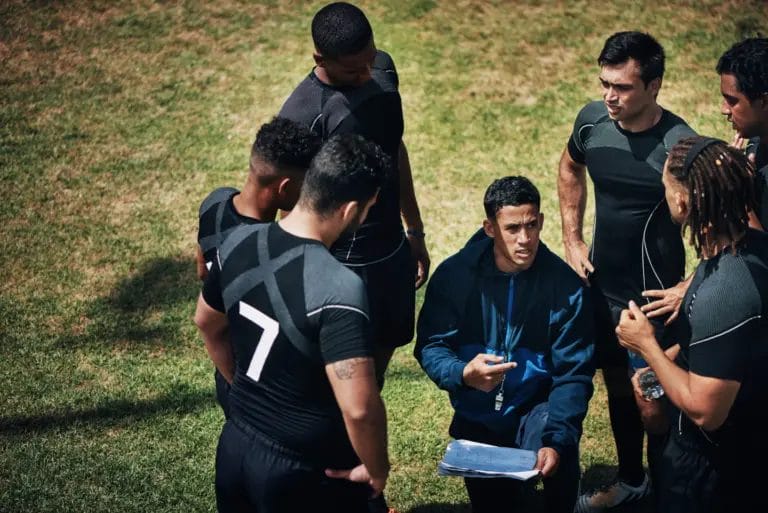 A coach talks to his adult rec league team during a game.