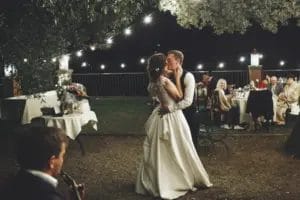 groom and bride kissing while dancing at a backyard wedding reception
