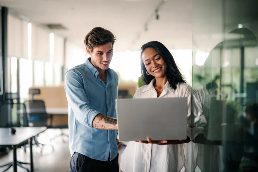 Client and confident consultant looking at a laptop in a modern office