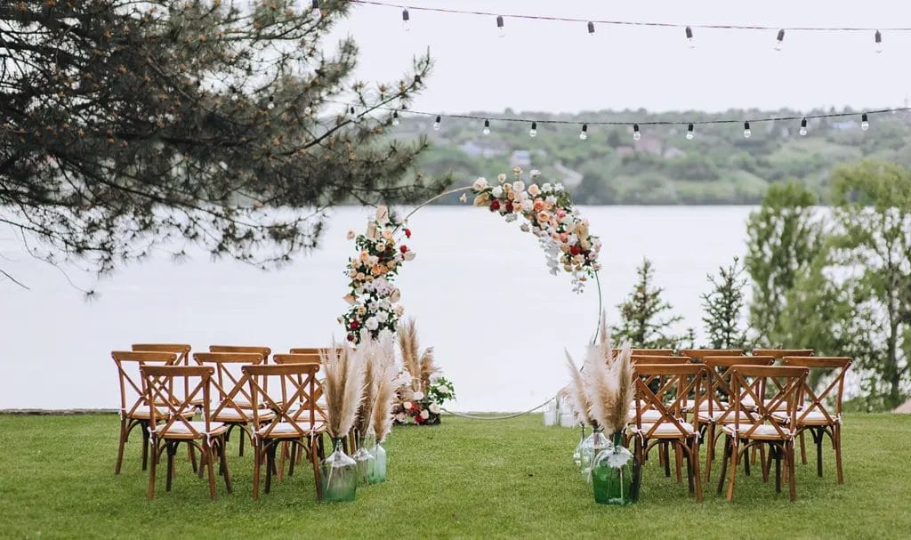 A small backyard wedding setup overlooks a scenic lake.