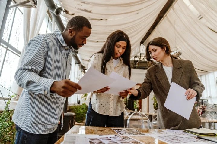 a young couple reviews paperwork with a business woman inside a wedding venue