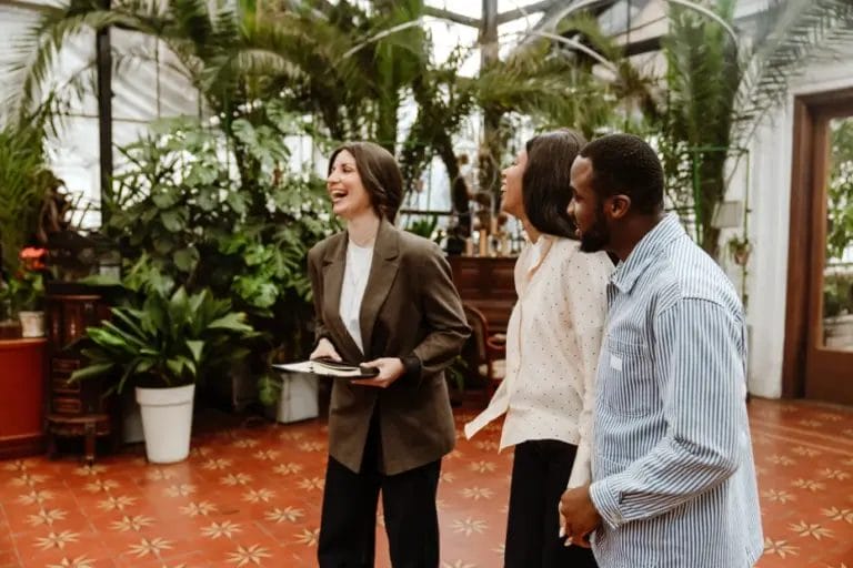 a couple and an event planner laughing while touring an indoor venue