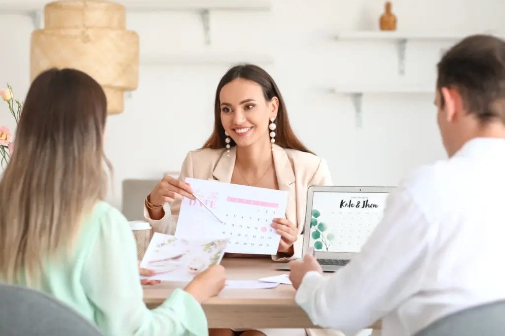 female wedding planner discussing calendar with clients in an office