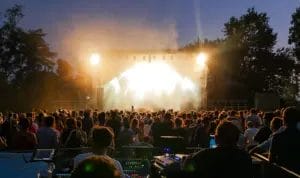 A crowd at a festival watching a performance on stage.