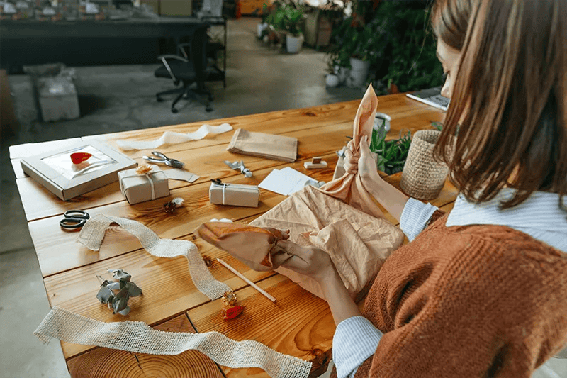 image of a woman wrapping an art piece with a cloth cover.