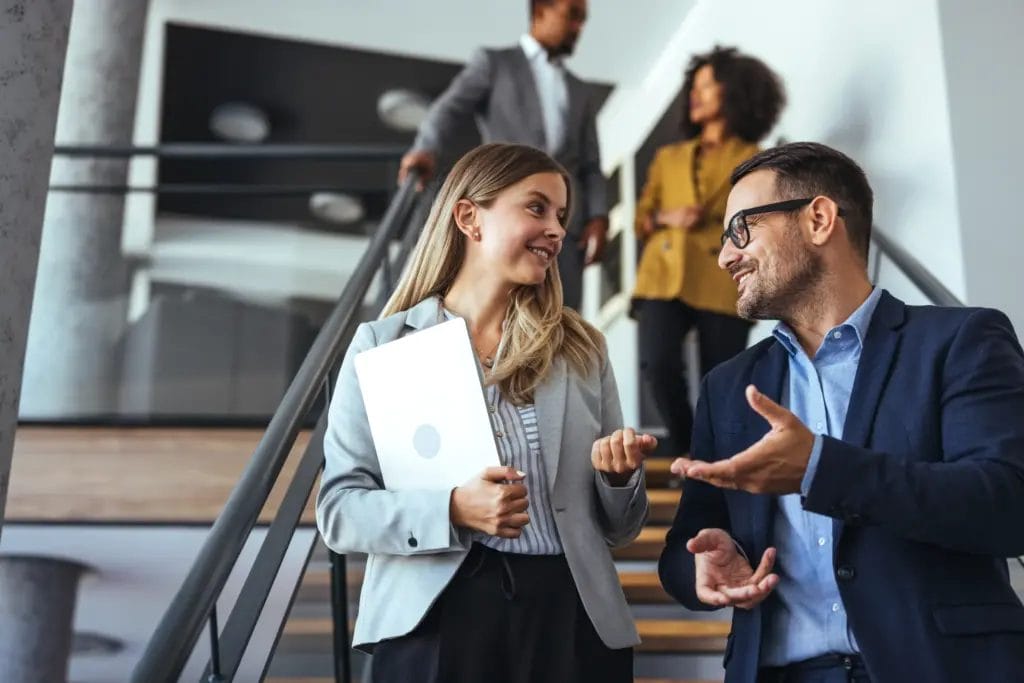 Corporate trainer talking to employee on staircase