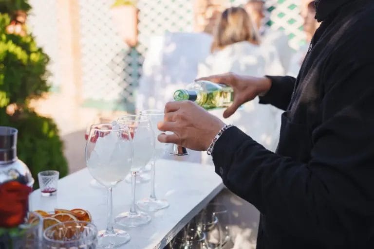 A bartender pours drinks for guests at an outdoor event