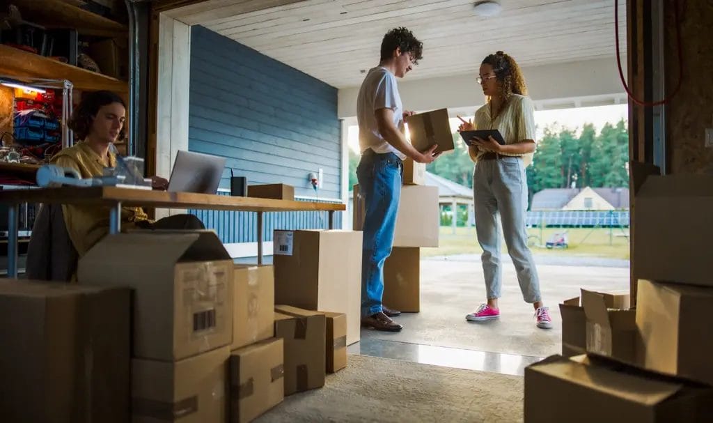 A crew of entrepreneurs go through product inventory in their home garage setup.